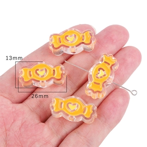Close-up of candy-shaped acrylic beads with heart pattern and 26x13mm size dimensions