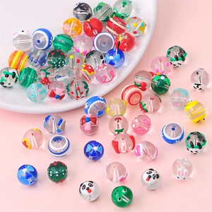 Detail shot of assorted hand-painted glass beads in a white bowl for jewelry making