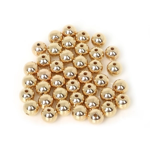 Close-up of polished gold CCB round spacer beads with holes for DIY jewelry making