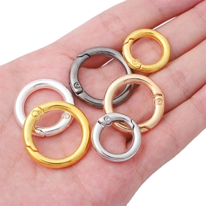 Diverse metalen veer-O-ringen in goud en zilver, in de hand gehouden voor de schaal