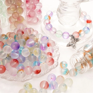 Macroshot van kleurrijke matglazen kralen met gouden glitters voor DIY sieraden maken