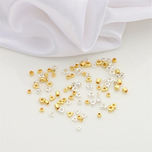 Mixed geometric gold and silver spacer beads on white silk for DIY jewelry making