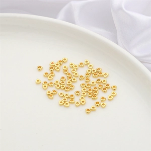 Macro shot of gold-plated triangle spacer beads for DIY jewelry making on a white plate