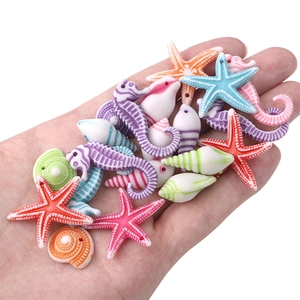 Close-up of colorful resin sea creature beads held in hand for DIY jewelry making