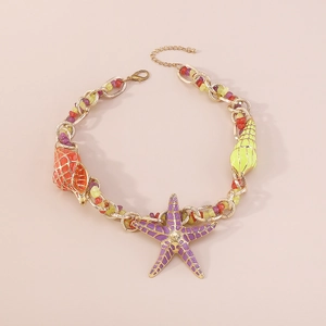 Dettaglio collana a catena dorata con pendente a stella marina viola e perline colorate