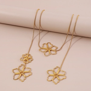 Detailed macro view of vintage golden alloy necklace with hollow flower pendants on snake chain