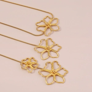 Macro shot of vintage style hollow metal flower pendants with golden snake chains