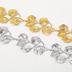 Detalle de los colgantes de hojas metálicas en oro y plata con textura de venas finas