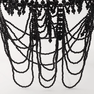 Dettaglio di catena per il corpo in perle nere multistrato con frange eleganti e lucide