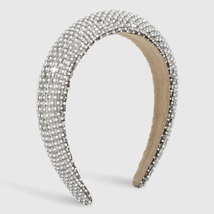 Close-up of padded headband with sparkling crystals and elegant white faux pearls