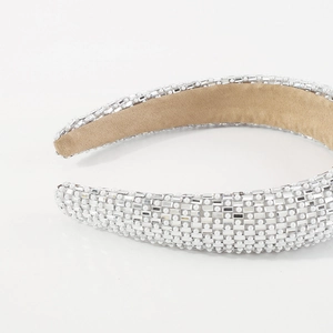 Close-up of wide velvet headband featuring sparkling crystals and white pearls detail