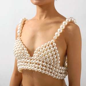 Détail d'un haut de bikini en perles blanches fait main avec de larges bretelles de plage