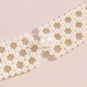 Détail d'un gilet chaîne de corps avec maillage en perles tissées et perle centrale ronde