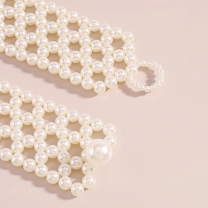Détail du gilet en perles tissées à la main avec perles blanches et fermoir élégant