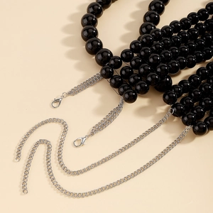 Vue détaillée de perles noires brillantes avec chaîne en métal argenté et mousquetons