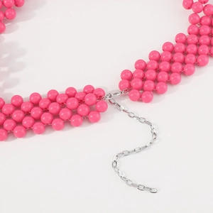 Détail de la chaîne de corps en perles roses avec tissage multi-rangs et fermoir argent