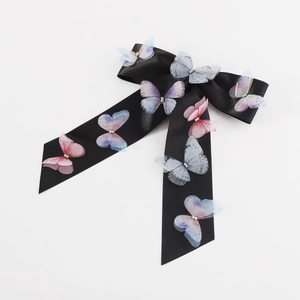 Detailed close-up of a black satin butterfly hair clip with colorful crystal embellishments