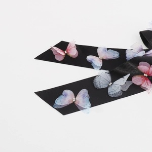 Detail of black satin hair ribbon with 3D gradient mesh butterflies and crystals