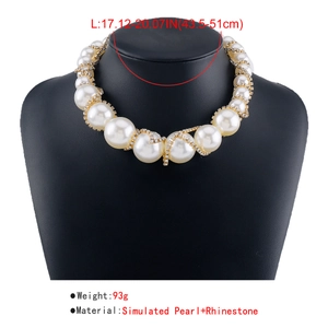 Detailed view of simulated pearl necklace with rhinestone-encrusted gold intertwining wires