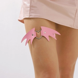Détail d'une jarretière en cuir rose avec boucle en métal cœur et motif d'aile