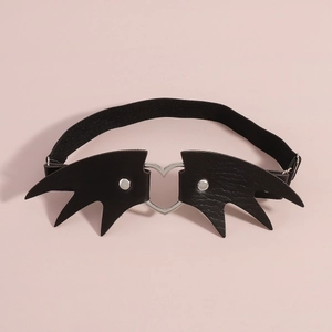 Détail d'une jarretière aile de cœur noire avec ailes de chauve-souris en cuir et rivets