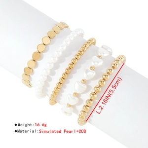 Vista de detalle del set de 5 pulseras elásticas doradas con perlas CCB y dijes de corazón
