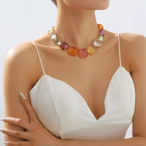 Détails des pierres précieuses carrées colorées sur le collier doré de style bohème