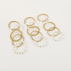 Vista macro de pulseras de perlas doradas y blancas con dijes de mariposa elegantes