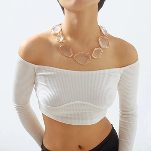 Detail of chunky geometric resin pendant necklace with gold frames on a female model