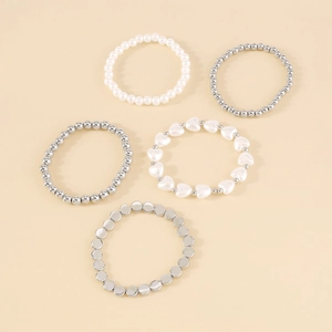 Detalle del juego de 5 pulseras multicapa con perlas y colgante de corazón plateado
