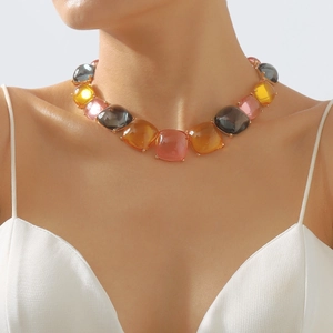 Détail macro du collier de pierres carrées en résine colorée avec montures dorées