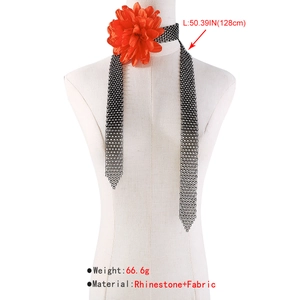 Detail view of rhinestone choker necklace with large orange fabric flower showing 128cm length