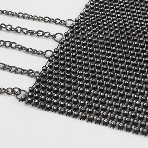 Detailed close-up of a black metal mesh body chain with shimmering clear rhinestones