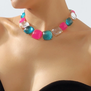 Gros plan d'un collier de grosses pierres en résine rose et sarcelle sur un mannequin