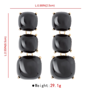 Vue détaillée des boucles d'oreilles pendantes noires avec base dorée et mesures de taille