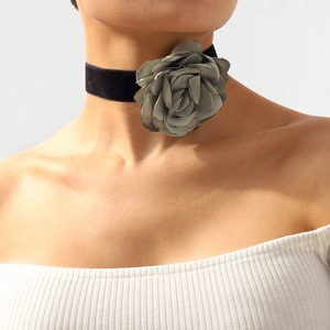 Detail of a large taupe fabric flower choker with a black velvet ribbon on a model