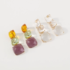 Détail de boucles d'oreilles géométriques en résine colorée et transparente de style