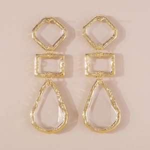 Detail of gold geometric drop earrings with hammered texture and clear crystal charms