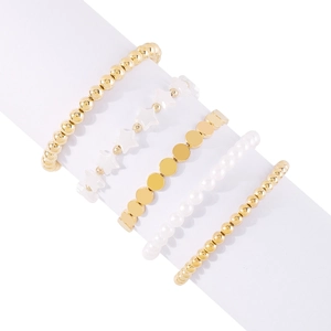 Detalle del juego de cinco pulseras de cuentas doradas y perlas en un soporte blanco