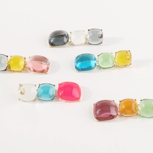 Vue détaillée de boucles d'oreilles aux pierres colorées taille pain de sucre et or