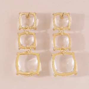 Détails macro de boucles d'oreilles géométriques à trois couches avec pierres transparentes