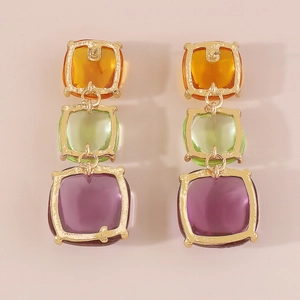 Vue détaillée des boucles d'oreilles bohèmes avec carrés en résine tricolore et cadres dorés