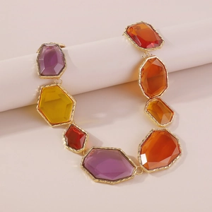 Detailed view of colorful resin gemstones with gold metallic textured edges on necklace