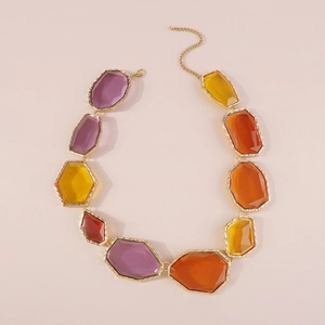 Detail of bohemian geometric multicolor resin necklace with hammered gold metal frames