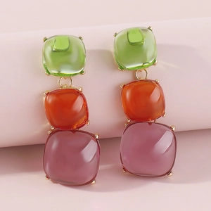 Vue détaillée de boucles d'oreilles carrées colorées avec monture en métal doré