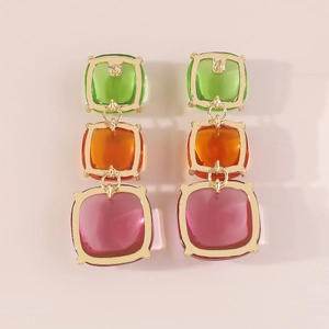 Détail de boucles d'oreilles pendantes géométriques à trois niveaux en pierres colorées