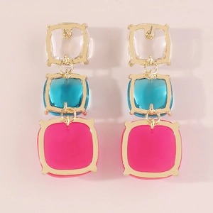 Vue détaillée de boucles d'oreilles carrées géométriques avec cadre doré et résine colorée