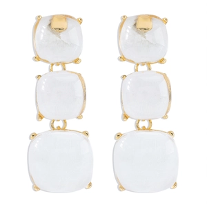 Détail de boucles d'oreilles dorées avec trois pierres carrées blanches translucides