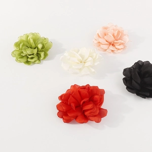 Detail of five handmade fabric rose flowers in satin green, white, pink, black and red