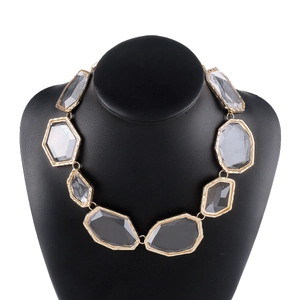Exaggerated geometric gray resin statement necklace on a black jewelry neck display